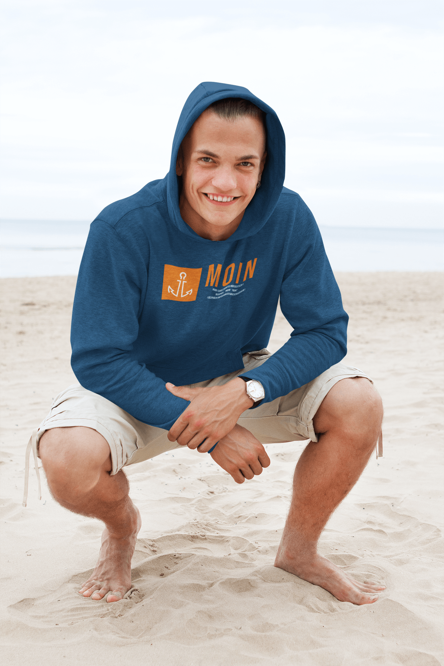 junger mann am strand mit einem moin hoodie aus dem bereich der maritimen mode